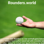 Hand holding a rounders ball. Rounders is a bat and ball game between two team that involves hitting a hard leather cased ball with a wooden bat.